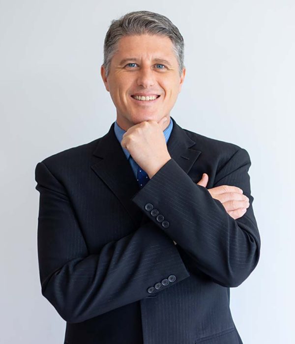 Portrait of positive confident businessman. Middle aged Caucasian man in jacket and tie touching chin and smiling at camera. Successful business leader concept